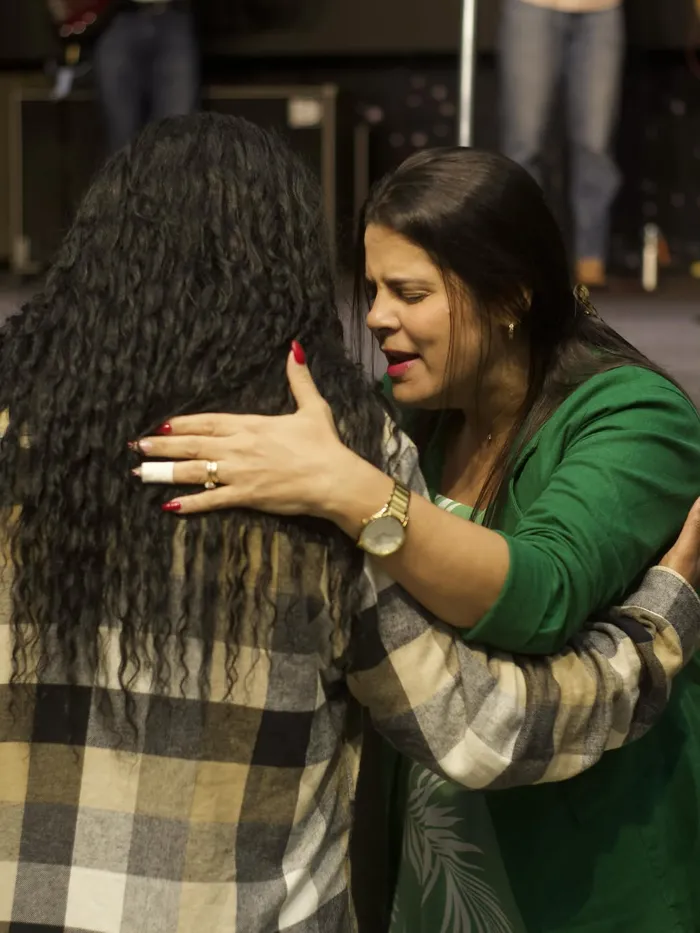 Duas mulheres se abraçando ao final de um culto